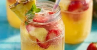 Ananas-Erdbeer-Bowle in einer Glaskaraffe mit frischen Früchten