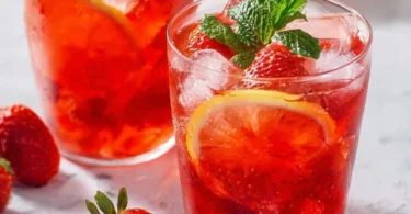Glas mit erfrischender Erdbeer Limonade und frischen Erdbeeren