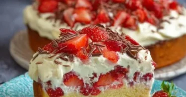 Fantakuchen mit Schmand und Erdbeeren auf einem Teller serviert.