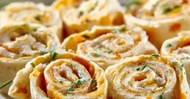 Leckere Frischkäse Roll-Ups auf einem Teller, ideal für Snacks oder Parties.