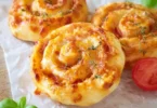 Vegetarische Blätterteigschnecken auf einem Teller, ideal für Snacks oder Partys.