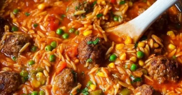 Bunte Orzo-Pfanne mit Hackbällchen und frischem Gemüse auf einem Teller