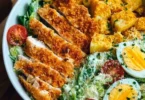 Leckere Caesar-Hähnchen-Bowl mit frischen Zutaten und Dressing