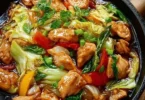 Chinesische Hähnchenpfanne mit Spitzkohl und Zwiebeln auf einem Teller