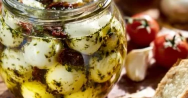 Eingelegter Mozzarella mit Kräutern und Gewürzen in einem Glas.