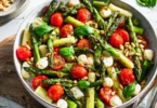 Grüner Spargel Salat mit Tomaten und Mozzarella auf einem schönen Teller