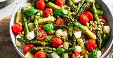 Grüner Spargel Salat mit Tomaten und Mozzarella auf einem schönen Teller