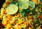Indisch gewürzter Reis Salat mit Mango in einer bunten Schüssel