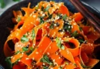Karottensalat mit Ingwer-Sesam-Dressing auf einem Teller