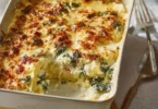 Mangold-Kartoffel-Auflauf serviert in einer Auflaufform, garniert mit frischen Kräutern.