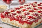 Spaghettieis-Blechkuchen mit Sahne und Schokoladensauce auf einem Blech serviert.
