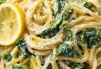 Zitronen-Ricotta-Pasta mit Spinat auf einem Teller serviert.